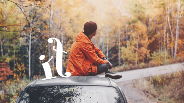 A guy sitting on the car in autumn season