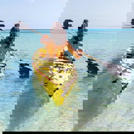 Instant Finance Travel Loan. Woman paddling a canoe