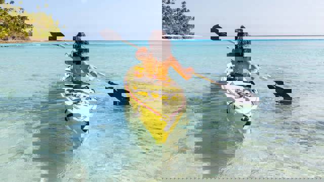 Instant Finance Travel Loan. Woman paddling a canoe