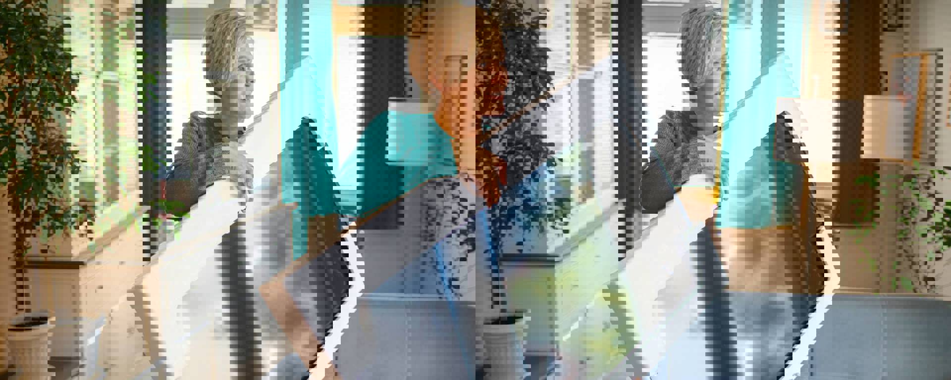 Woman in teal coloured top holding a new TV thanks to Instant Finance cash loans
