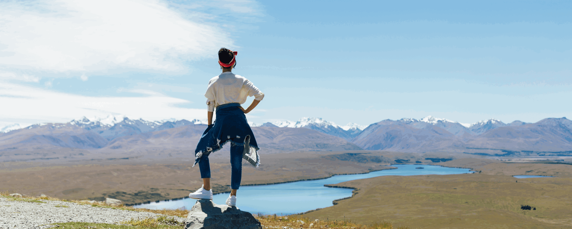 Woman looking out from a cliff top at a mountain range in New Zealand. Nationwide personal loans available at Instant Finance