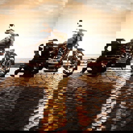 Man at sunset with his motorbike thinking about motorbike finance