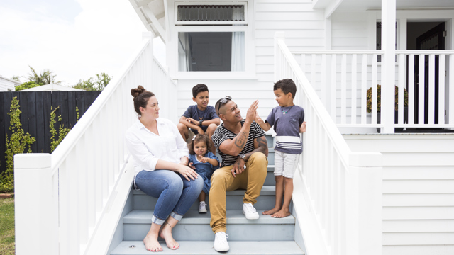 Family sitting on steps outside home, thinking about Life and Funeral Insurance