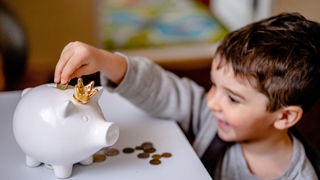 Entering money into a piggy bank for debt management, financial planning 
